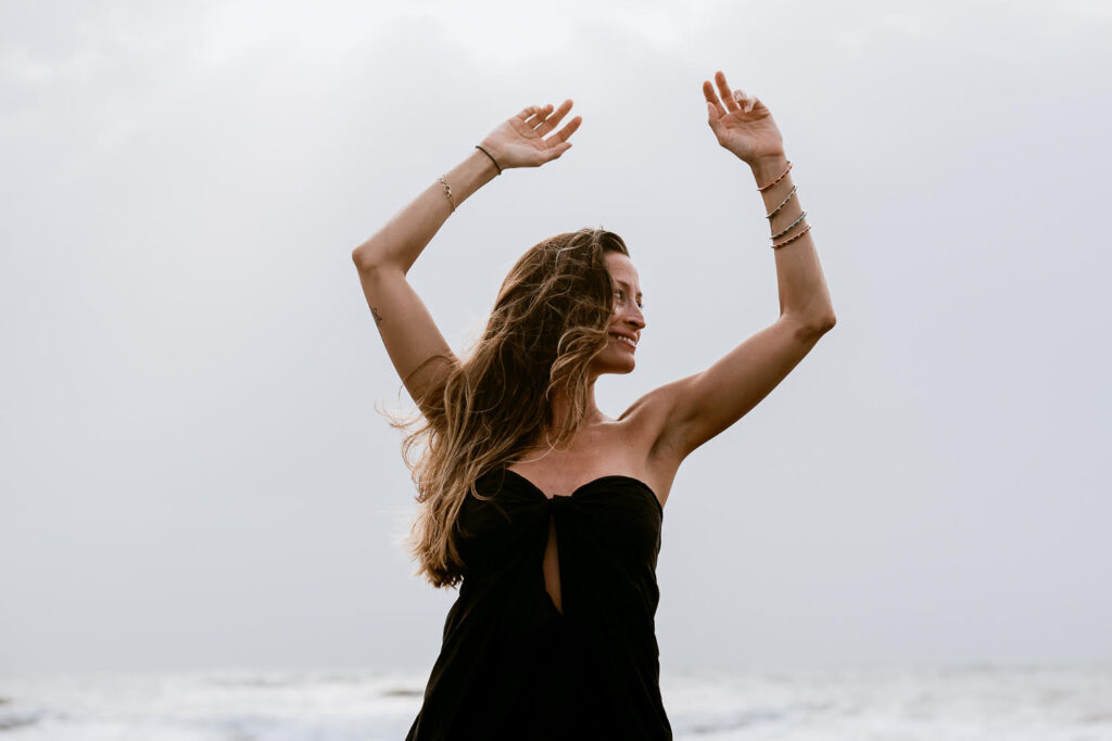 Rebecca Loos with arms raised to the sky.